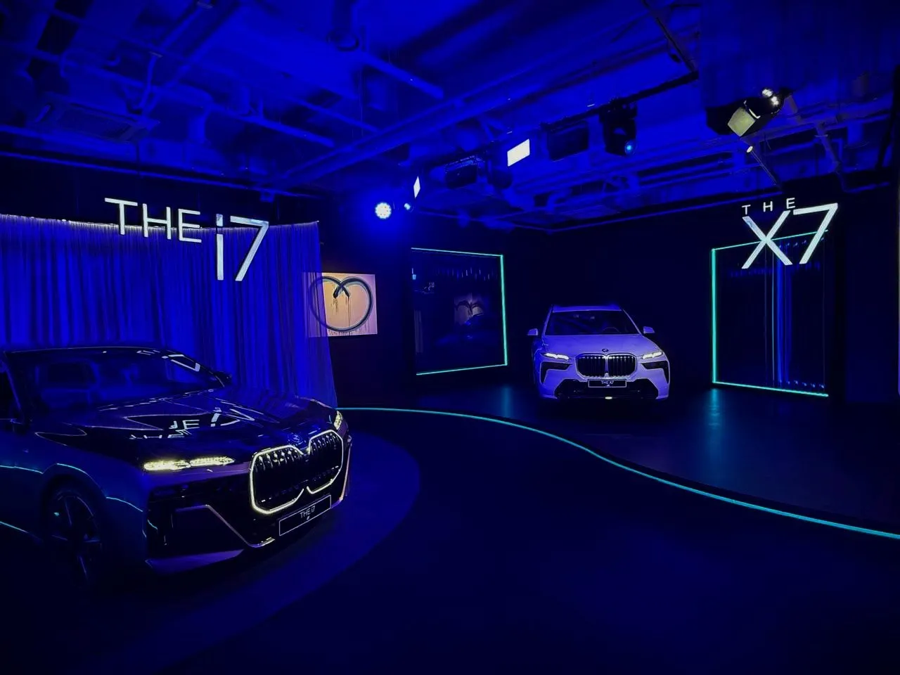 A brand event hall with a new car on display under blue lighting