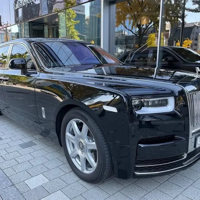 A black Rolls-Royce parked in front of a building