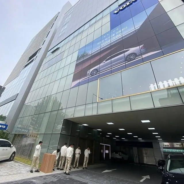 A Volvo showroom building with staff waiting at the entrance